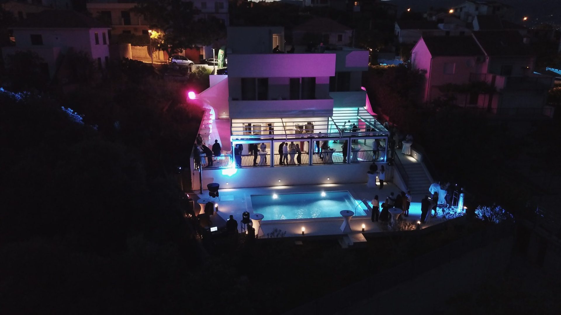 magico apartments aerial view pool party night