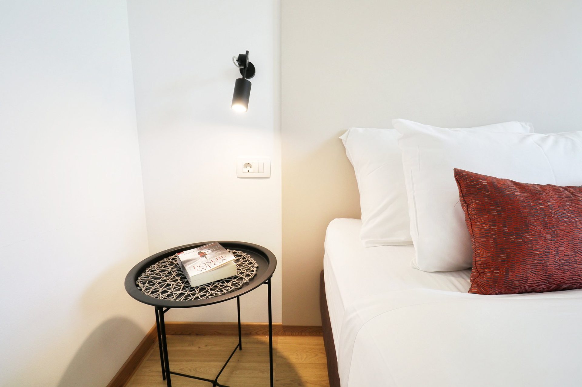 magico apartments bedside lamp red pillow detail